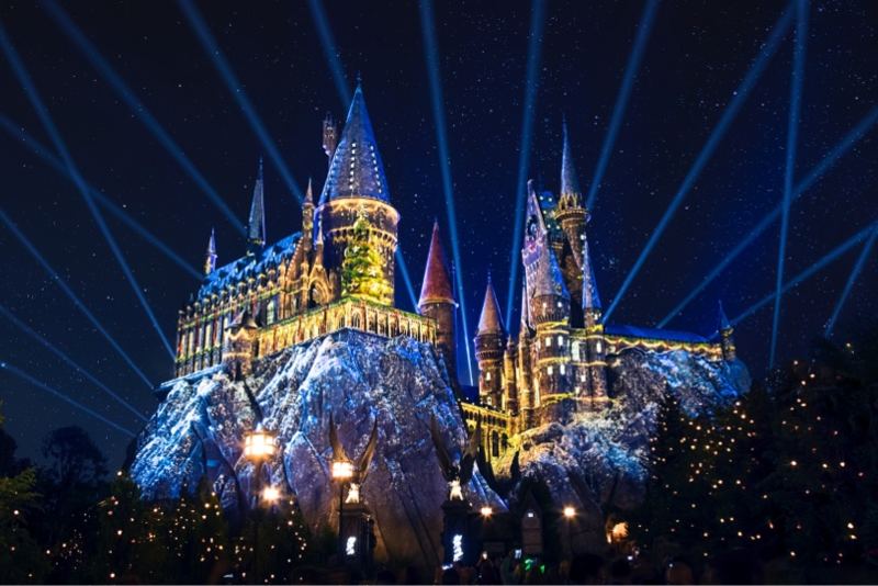 Hogwarts castle lit with holiday projections